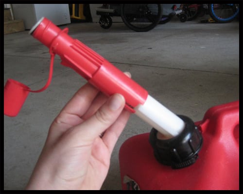 Remove the gas can cap and grasp the red sleeve. The sleeve is spring-loaded, so you will notice some resistance.